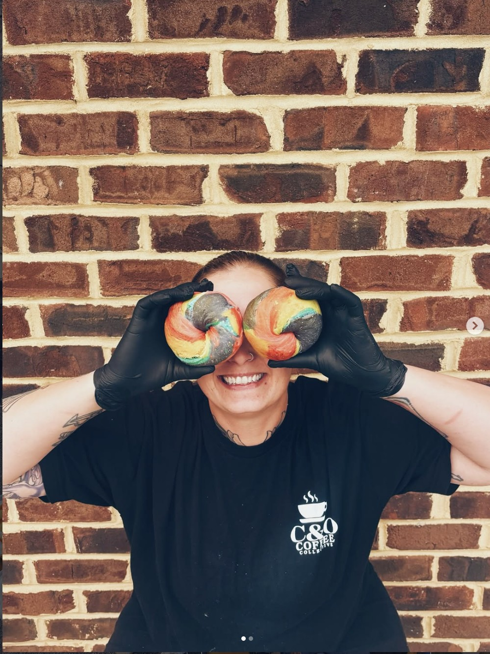 A C&O team member holding rainbow bagels